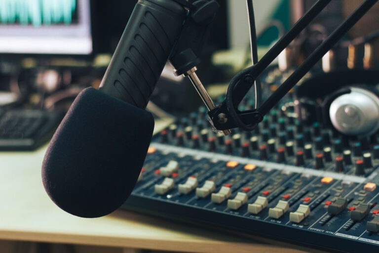 Radio host microphone, mixing console and headphones close-up